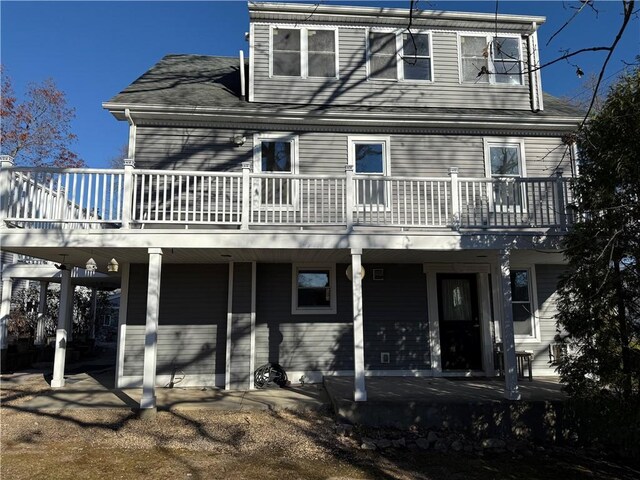 view of front of property featuring roof with shingles and a wooden deck