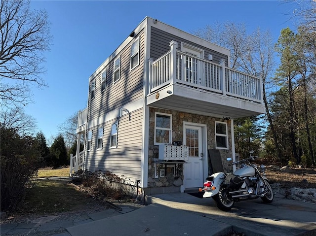view of front of home with a balcony and stone siding
