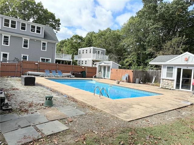 view of pool with an outdoor structure, a fenced backyard, and a patio area