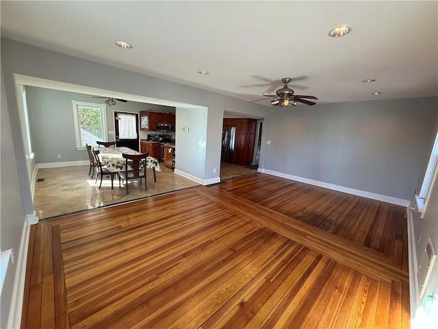 living room with wood-type flooring, a ceiling fan, baseboards, and recessed lighting