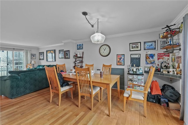 dining area featuring crown molding and light wood-style floors