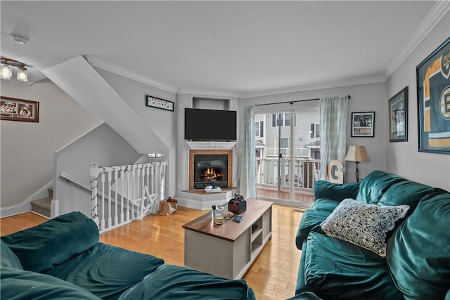 living room with ornamental molding, wood finished floors, and a fireplace