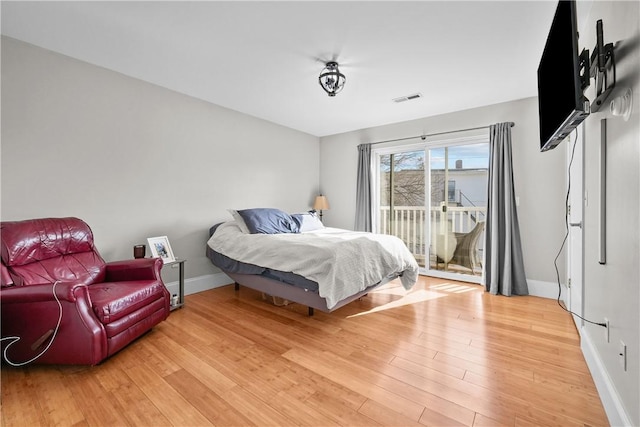bedroom with access to exterior, baseboards, and light wood finished floors