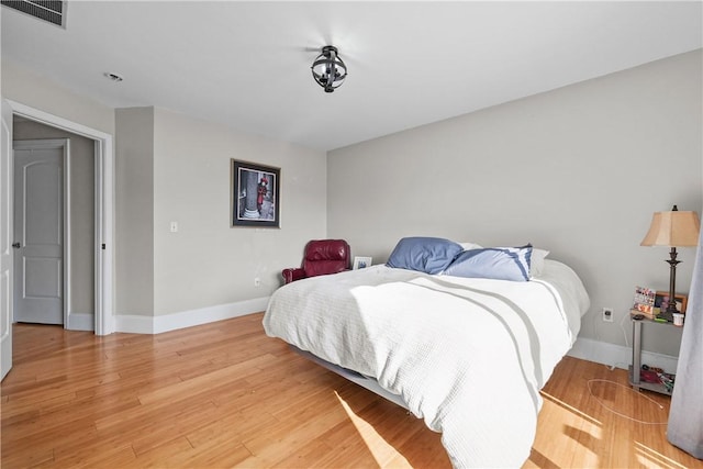 bedroom featuring baseboards and light wood finished floors