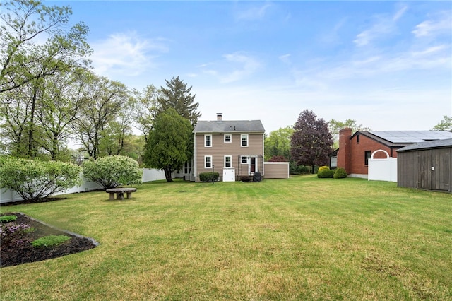 rear view of house with an outdoor structure, a storage shed, and a chimney