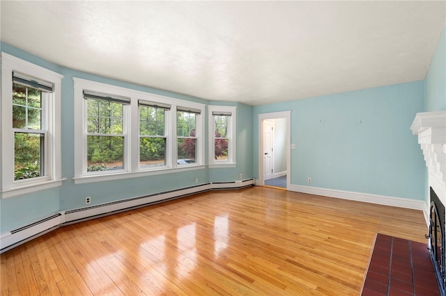 unfurnished living room featuring light wood-style flooring, a fireplace with flush hearth, a baseboard radiator, and baseboards