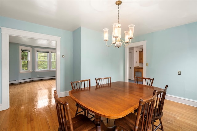 dining area featuring baseboard heating, light wood-style flooring, a chandelier, and baseboards
