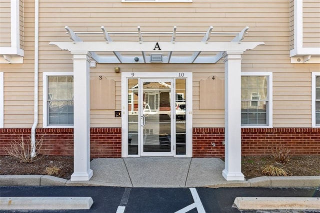 60 Bay Spring Ave Unit A9, Barrington, RI 02806 - property entrance with brick siding, uncovered parking, and a pergola