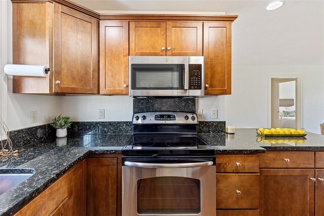 60 Bay Spring Ave Unit A9, Barrington, RI 02806 - kitchen featuring stainless steel appliances, brown cabinetry, and dark stone counters