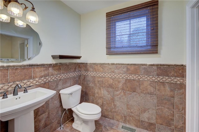 34 Ledgefield Rd, Scituate, RI 02857 - half bathroom with toilet, tile walls, a sink, and wainscoting
