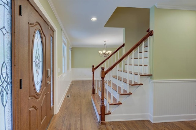 34 Ledgefield Rd, Scituate, RI 02857 - entryway with wood finished floors, a wainscoted wall, a chandelier, crown molding, and stairway