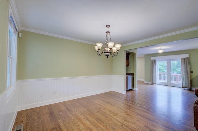 34 Ledgefield Rd, Scituate, RI 02857 - empty room featuring wood finished floors, crown molding, a chandelier, a wainscoted wall, and french doors