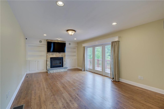 34 Ledgefield Rd, Scituate, RI 02857 - unfurnished living room featuring a fireplace, baseboards, wood finished floors, built in shelves, and recessed lighting