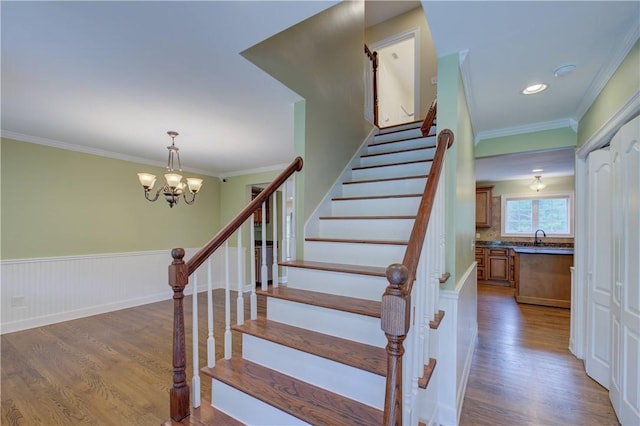 34 Ledgefield Rd, Scituate, RI 02857 - staircase with wood finished floors, ornamental molding, a chandelier, and a wainscoted wall