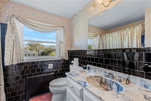 54 Glenwood Dr, North Kingstown, RI 02852 - bathroom with tile walls, toilet, radiator, wallpapered walls, and vanity