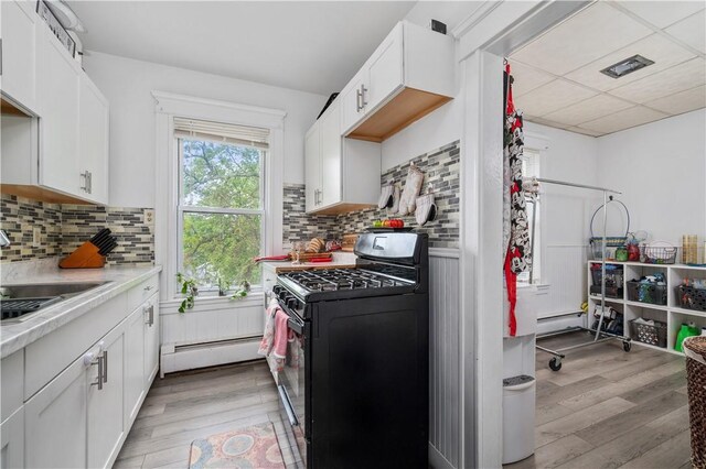 645 Providence St, Woonsocket, RI 02895 - kitchen with black range with gas stovetop, a baseboard heating unit, light wood-style floors, light countertops, and a sink