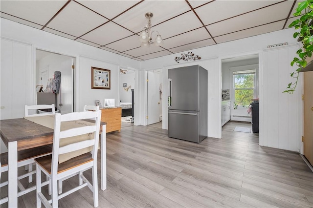 645 Providence St, Woonsocket, RI 02895 - dining space with a chandelier, a baseboard heating unit, and light wood-style flooring