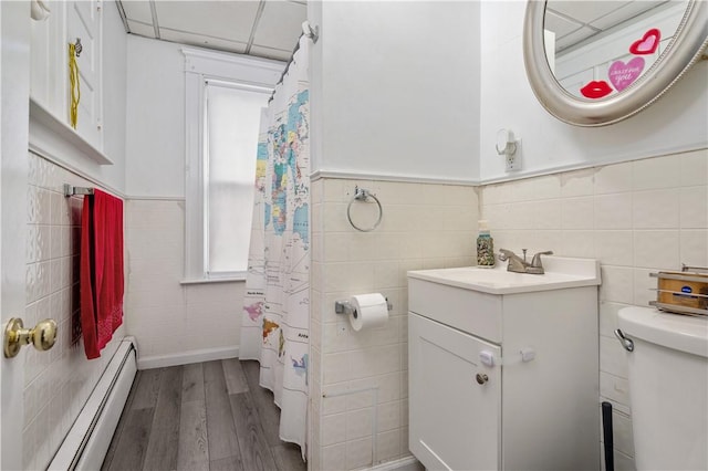 645 Providence St, Woonsocket, RI 02895 - bathroom with a baseboard radiator, tile walls, wood finished floors, toilet, and vanity