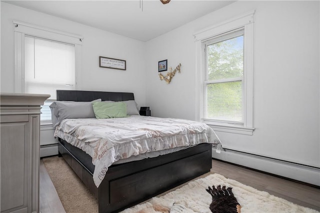 645 Providence St, Woonsocket, RI 02895 - bedroom featuring wood finished floors, a baseboard radiator, baseboard heating, and a ceiling fan
