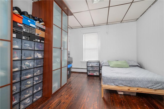 645 Providence St, Woonsocket, RI 02895 - bedroom with baseboard heating, dark wood-style floors, and a paneled ceiling