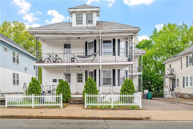 645 Providence St, Woonsocket, RI 02895 - view of front facade with a balcony, a porch, a fenced front yard, and a shingled roof