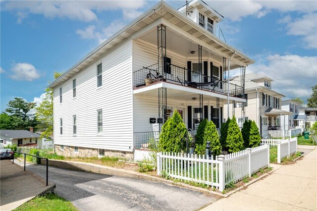 645 Providence St, Woonsocket, RI 02895 - view of front of house with a balcony, fence, and a porch