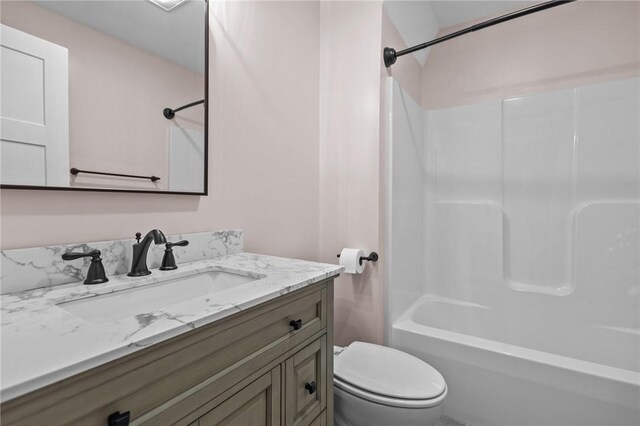 bathroom with toilet, vanity, and shower / tub combination