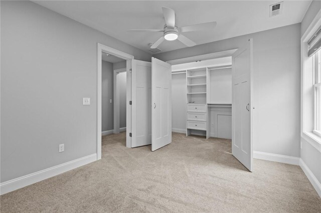 unfurnished bedroom featuring light carpet, multiple windows, and baseboards