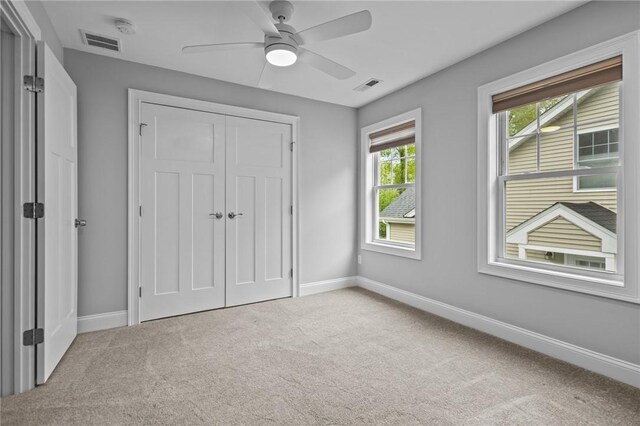 unfurnished bedroom featuring carpet floors, baseboards, a closet, and a ceiling fan