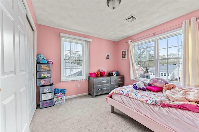 bedroom with multiple windows, carpet flooring, baseboards, and a closet