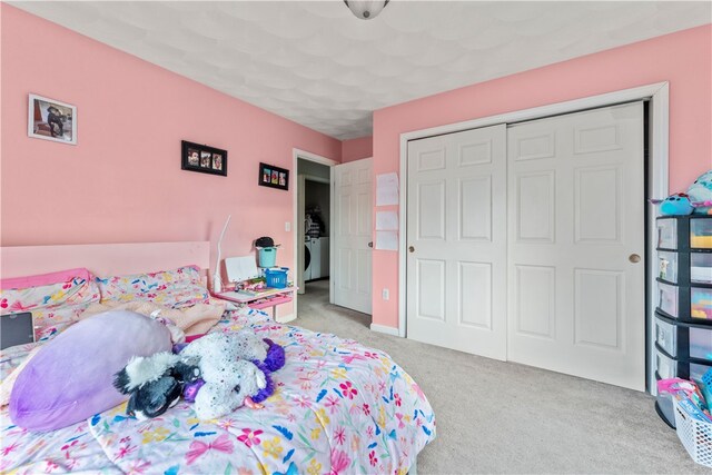 carpeted bedroom featuring a closet and washer / dryer