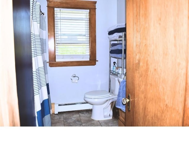 bathroom featuring baseboard heating and toilet
