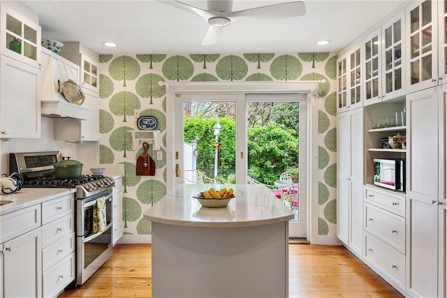 15 Cross St, Newport, RI 02840 - kitchen featuring double oven range, wallpapered walls, light countertops, white cabinets, and a kitchen island