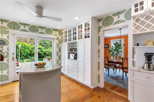 15 Cross St, Newport, RI 02840 - kitchen with a ceiling fan, light wood-style flooring, white cabinetry, light countertops, and a center island