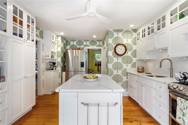 15 Cross St, Newport, RI 02840 - kitchen with appliances with stainless steel finishes, a sink, a center island, ceiling fan, and light wood-style flooring