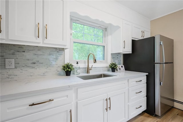 7 Maggio Ave, Westerly, RI 02891 - kitchen featuring a sink, white cabinets, crown molding, freestanding refrigerator, and light stone counters