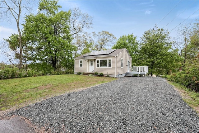 7 Maggio Ave, Westerly, RI 02891 - bungalow-style house featuring driveway, roof mounted solar panels, a front lawn, and a deck