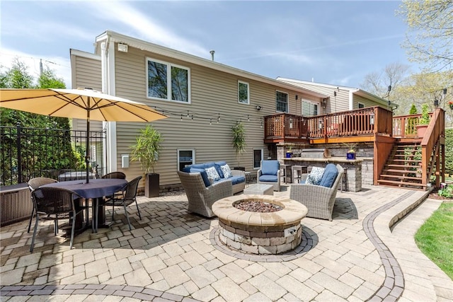 back of property featuring stairs, a patio, a deck, outdoor dining space, and an outdoor living space with a fire pit