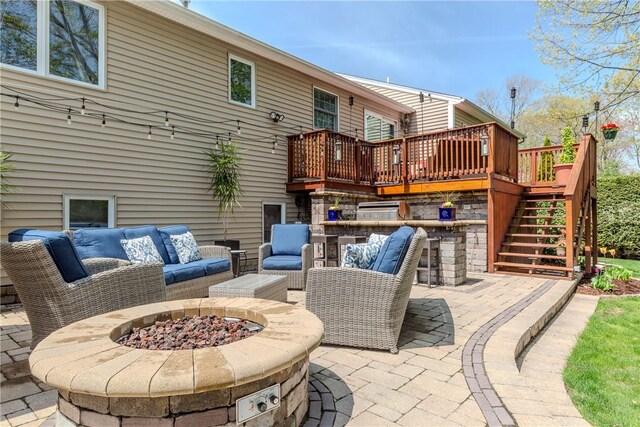 view of patio with stairway, an outdoor living space with a fire pit, and a wooden deck