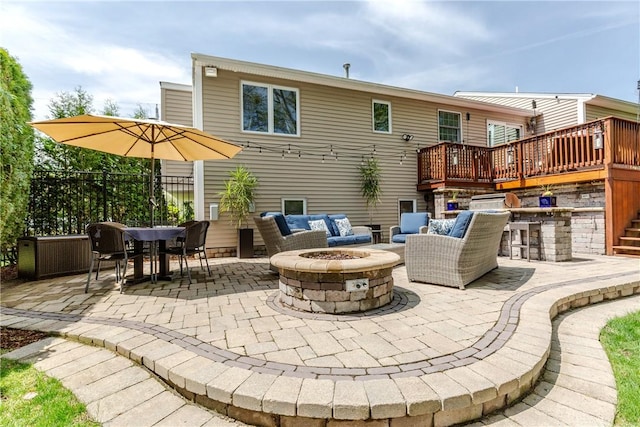 rear view of house featuring a patio area, a deck, and an outdoor living space with a fire pit