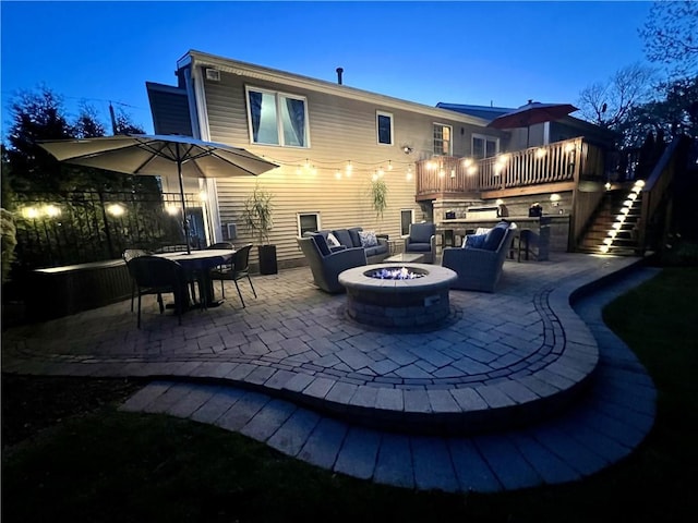 rear view of house with stairway, a patio, an outdoor living space with a fire pit, and a wooden deck