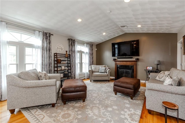 living room with wood finished floors, a fireplace, recessed lighting, lofted ceiling, and baseboards