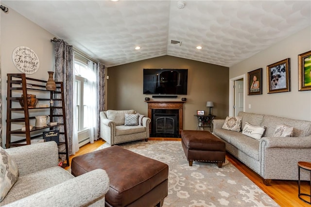 living area featuring wood finished floors, vaulted ceiling, a fireplace, and recessed lighting
