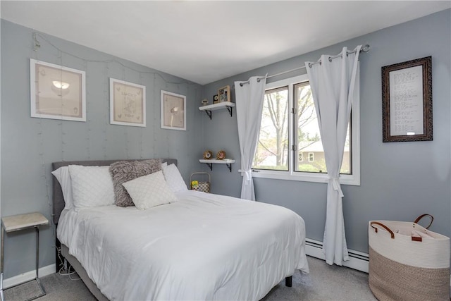 carpeted bedroom with baseboard heating and baseboards