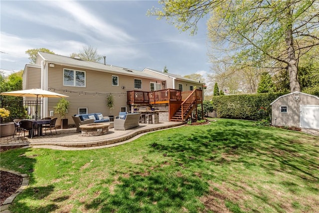 back of house featuring a wooden deck, a patio area, a storage shed, stairway, and an outbuilding