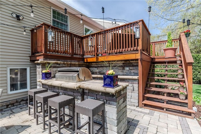 view of patio / terrace with exterior kitchen, stairs, a deck, and an outdoor bar