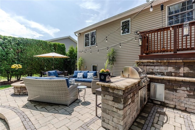 view of patio / terrace with exterior kitchen, an outdoor hangout area, and a wooden deck