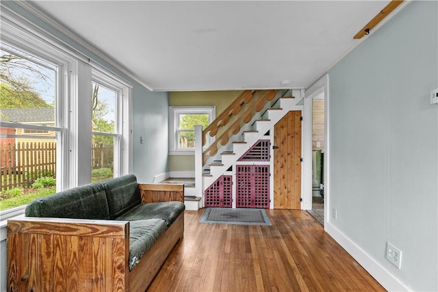 living room featuring baseboards, hardwood / wood-style flooring, stairway, and ornamental molding