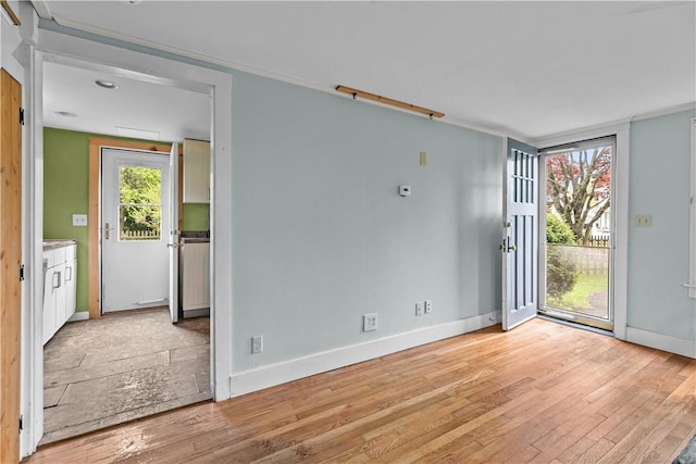 unfurnished room with light wood-style flooring and baseboards