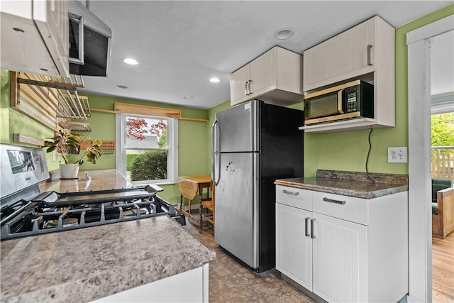 kitchen featuring stainless steel appliances, white cabinets, and recessed lighting